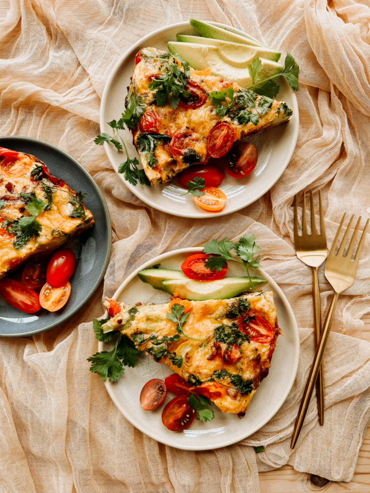 three plate with slices of kitchen sink frittata resting on a tan cloth
