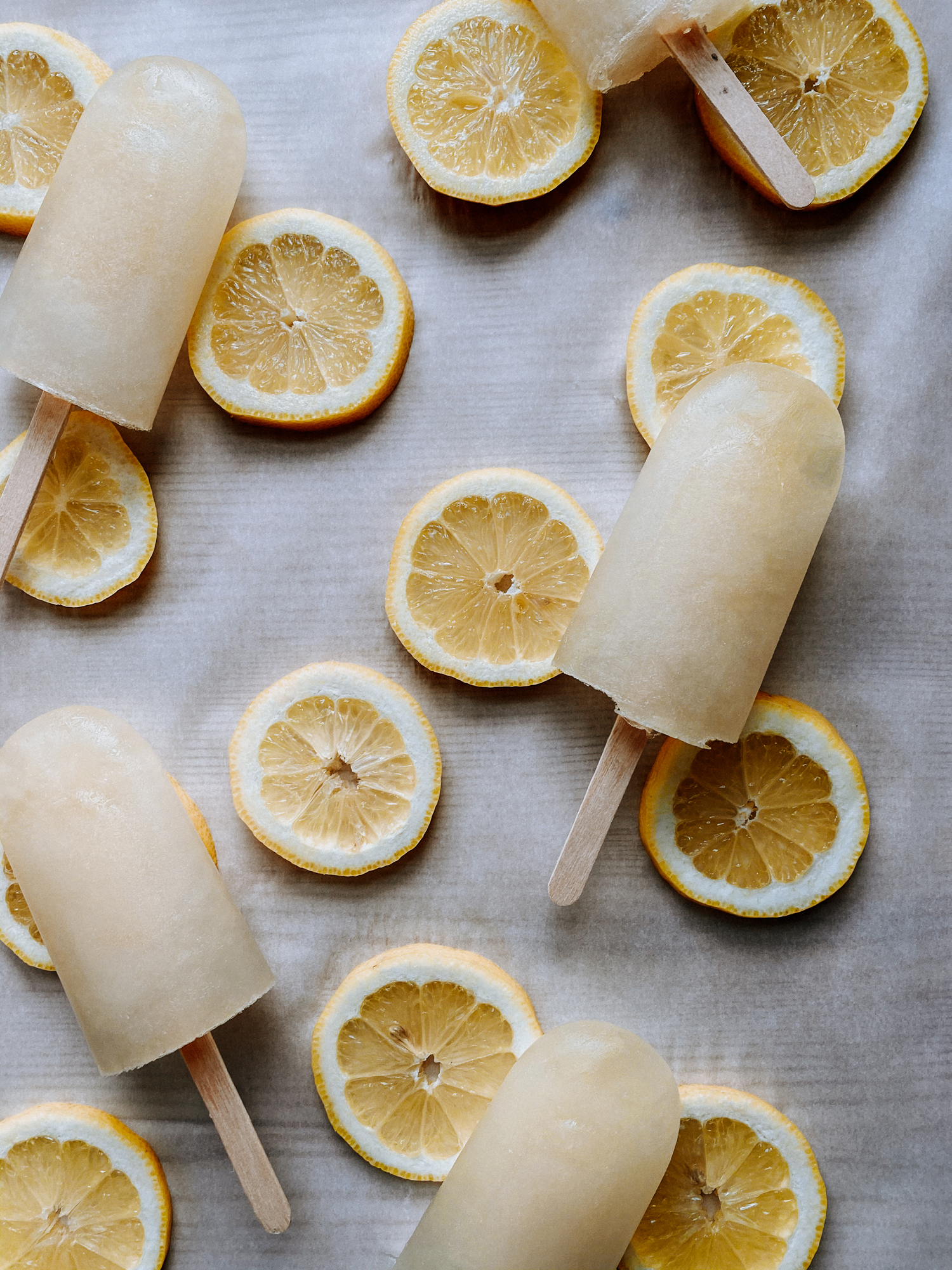 a white surface with lemon slices and harry potter lemon ice pops resting on top