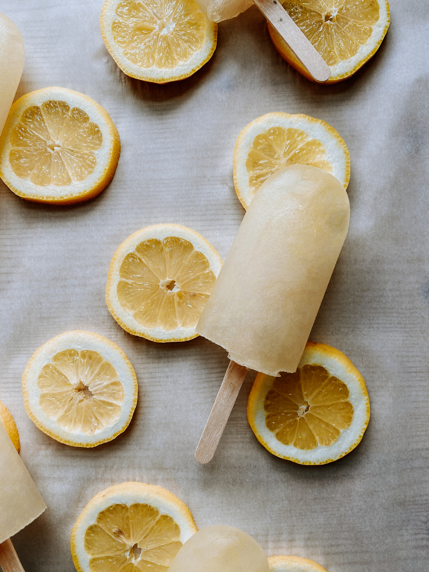 harry potter inspired lemon ice pops resting on top of lemon slices on a white surface