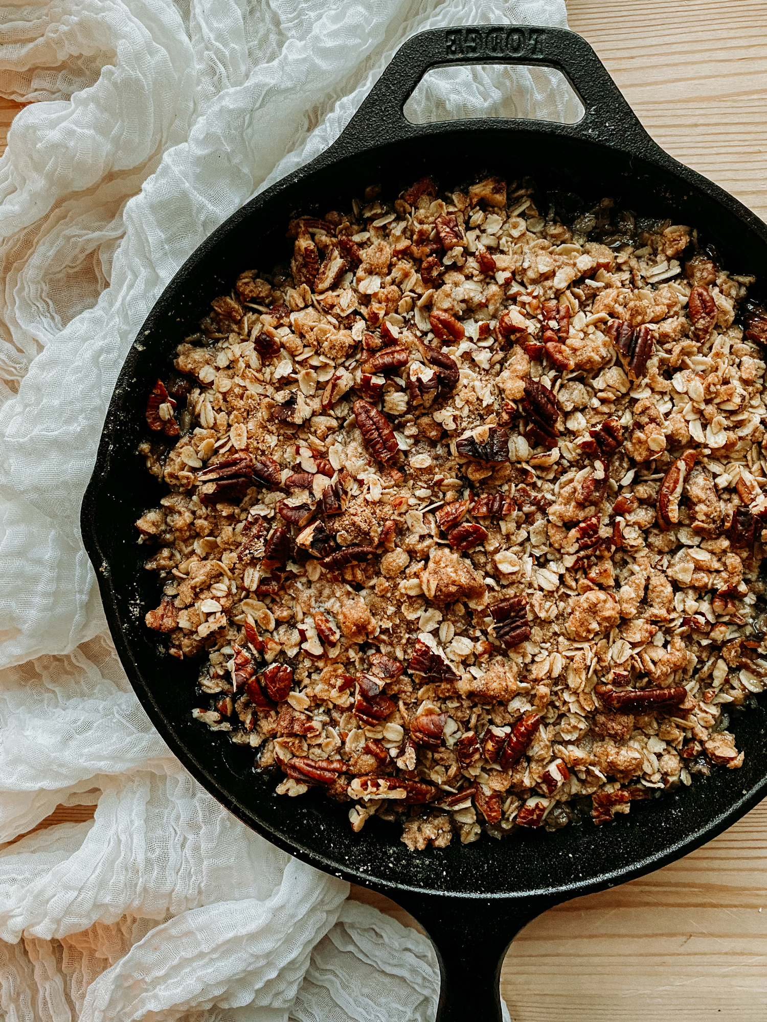 Spiced Pear Crisp in a cast iron pan on a neutral colored cloth