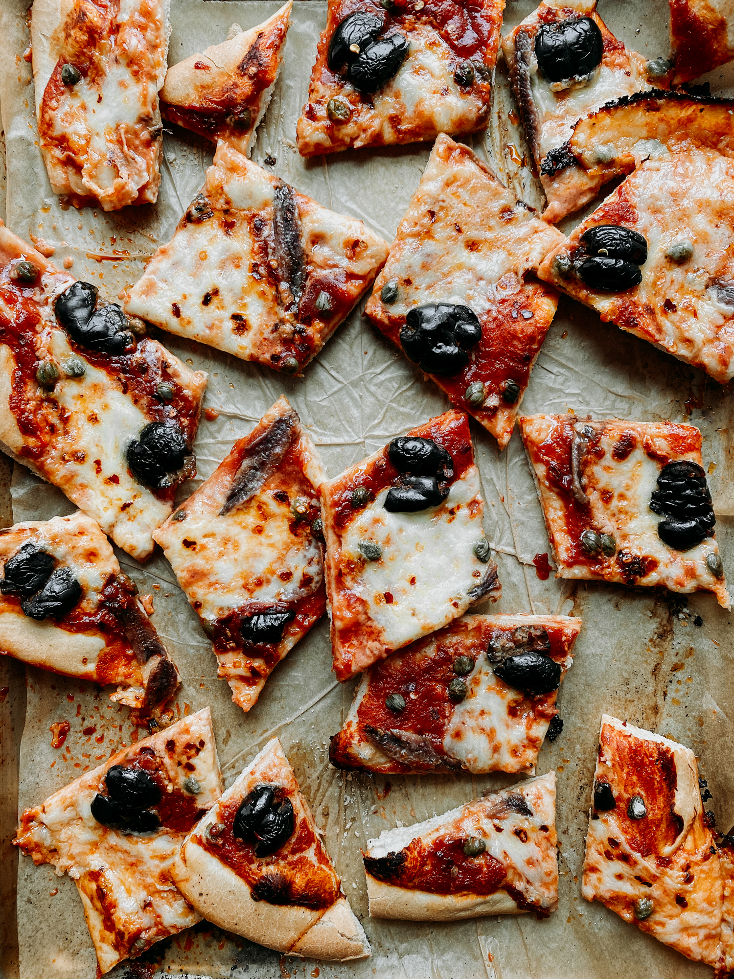 pieces of Pizza Puttanesca in a baking sheet
