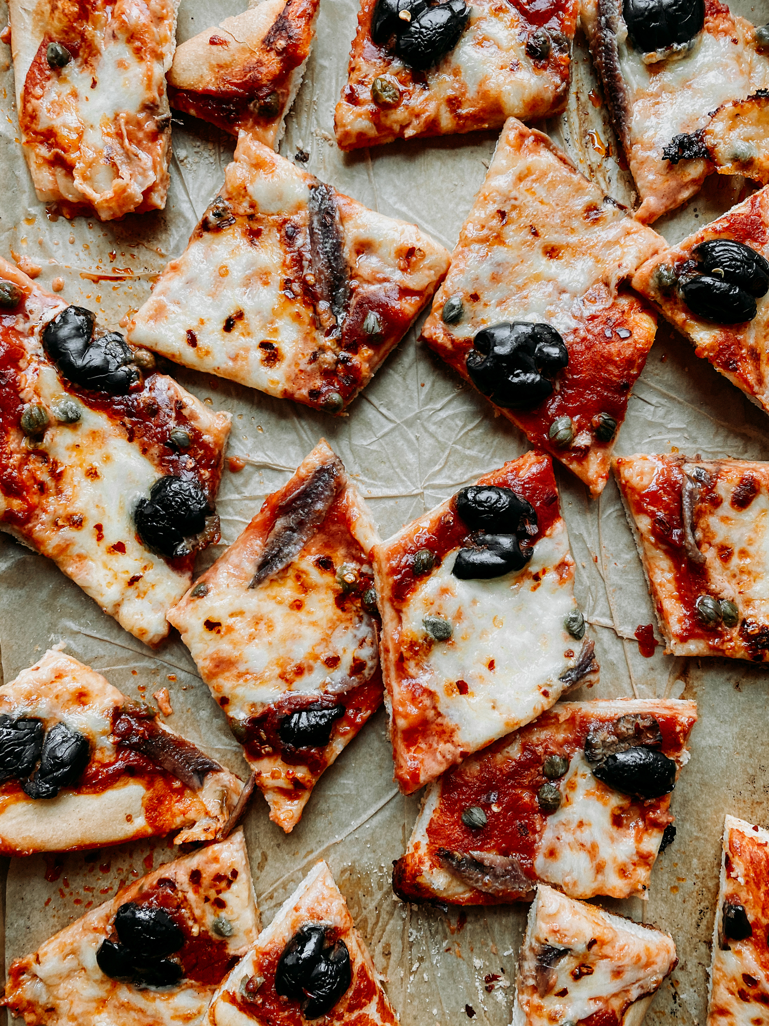a baking sheet covered in pieces of Pizza Puttanesca