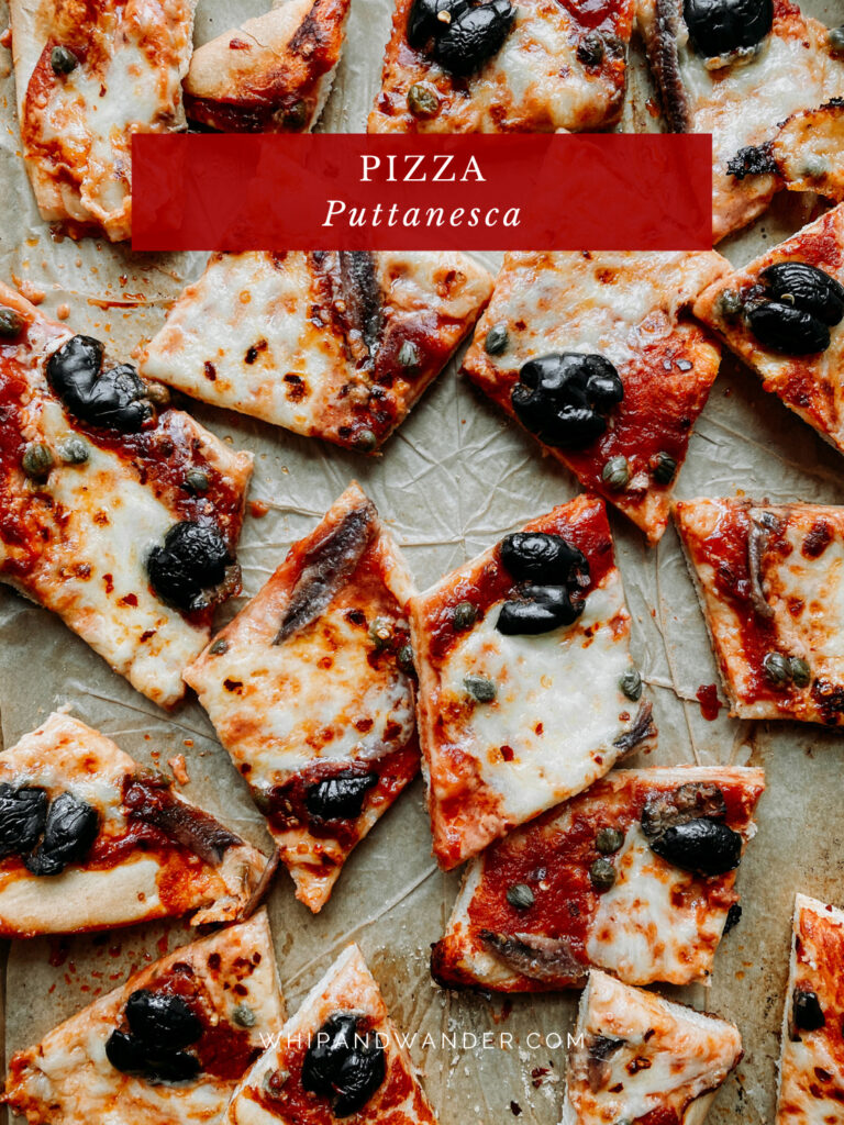 pieces of Pizza Puttanesca resting on a parchment lined baking sheet
