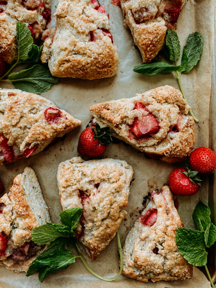 Sourdough Discard Strawberry Mint Scones on a baking sheet with fresh strawberries and mint springs on the tray