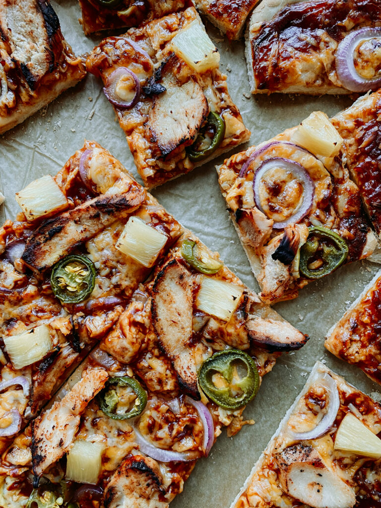 square slices of pizza with bbq sauce, bbq chicken, and veggies
