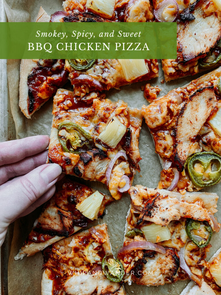 a hand grabbing a slice of pizza with bbq sauce and chicken off of a baking tray