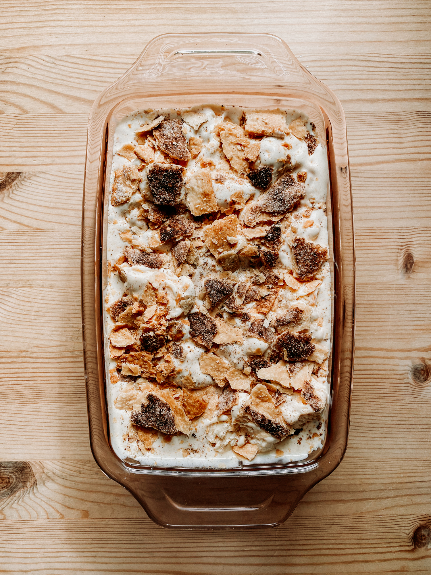 soft serve textured Buttermilk Peach Pie Ice Cream in a pink glass loaf pan before freezing solid