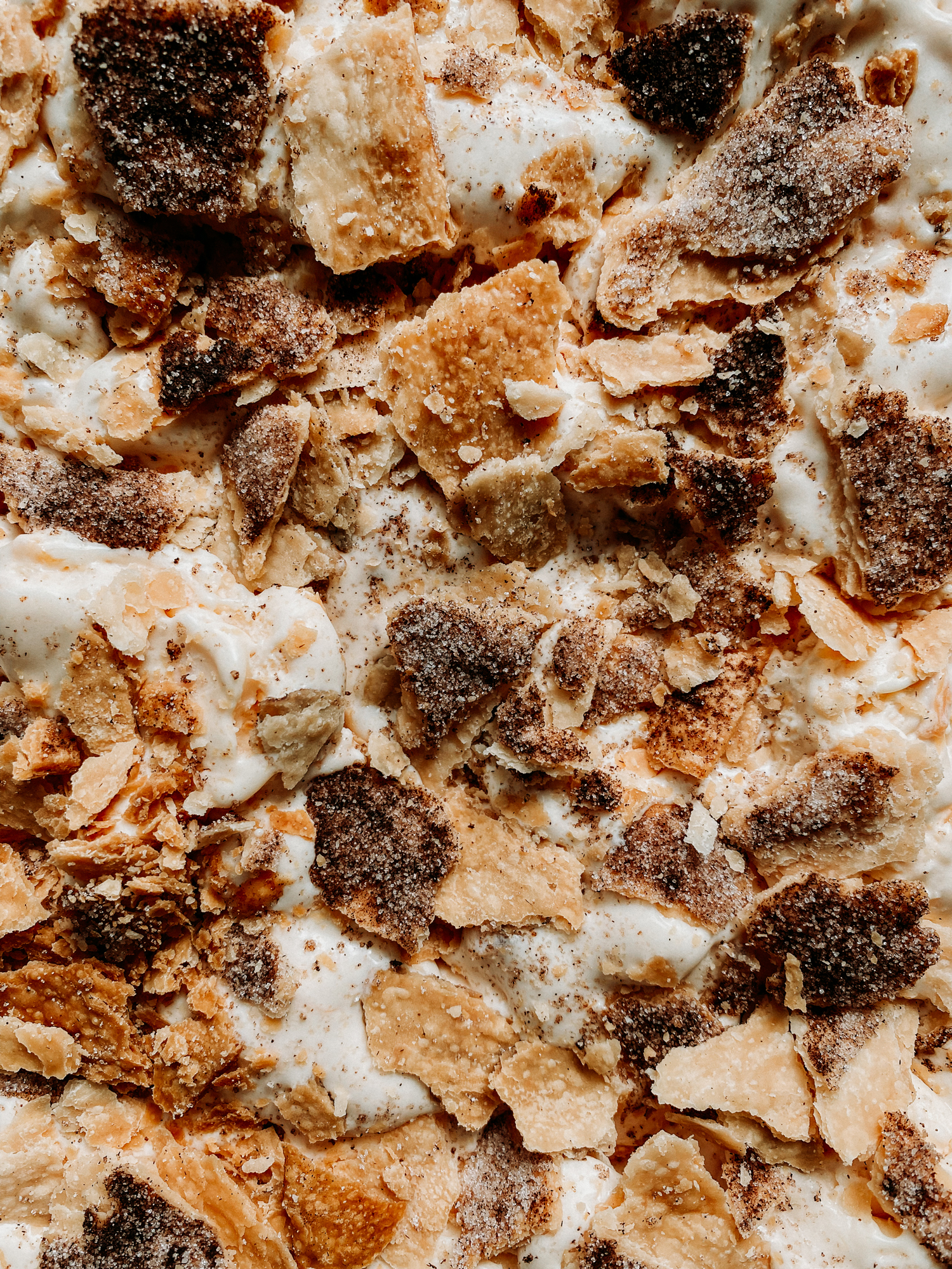 closeup of pie crust dotted within peach ice cream