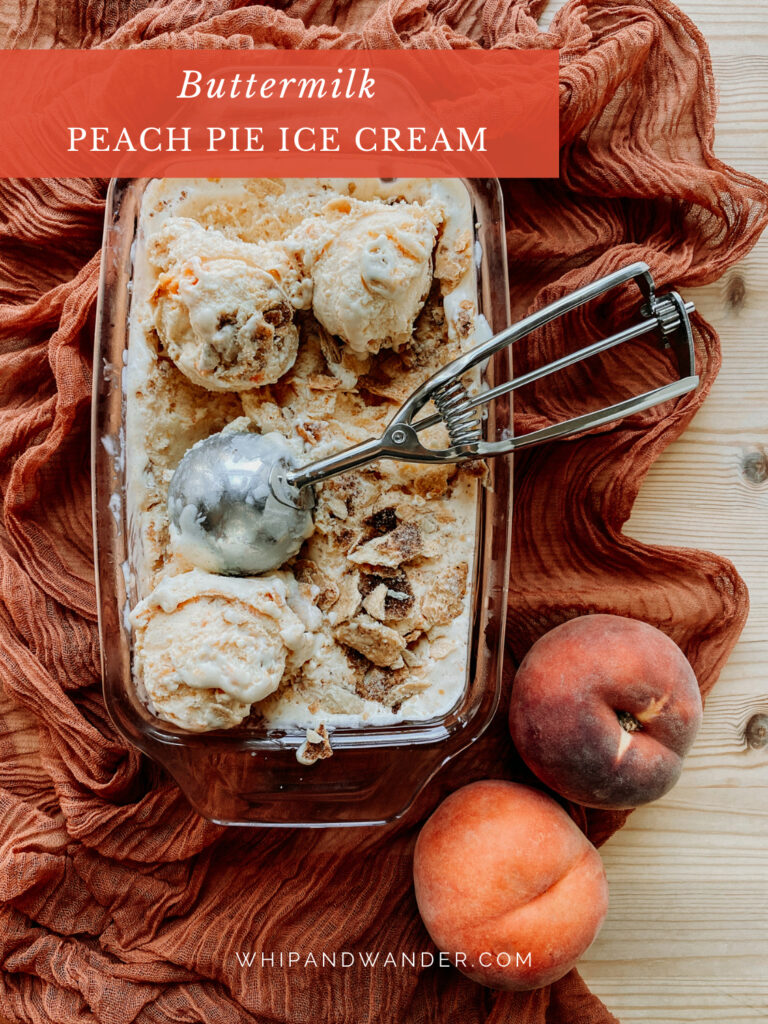 a pan of Buttermilk Peach Pie Ice Cream with a metal ice cream scoop resting in the glass pan
