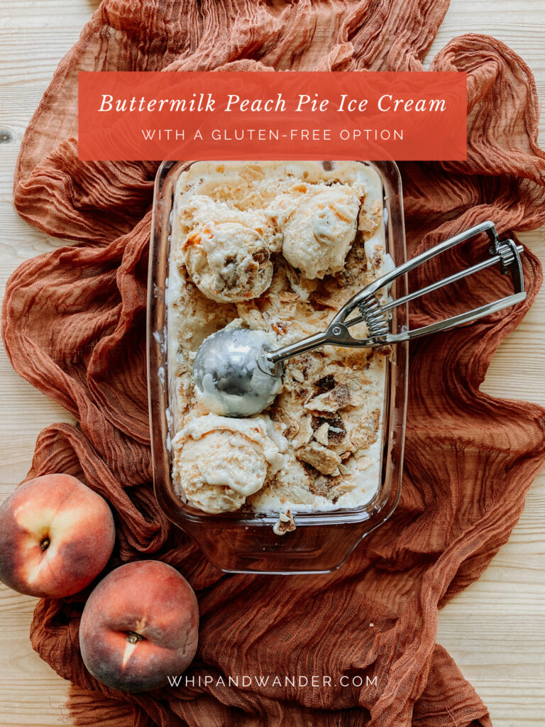 a pan of Buttermilk Peach Pie Ice Cream with a metal ice cream scoop and fresh peaches on a table