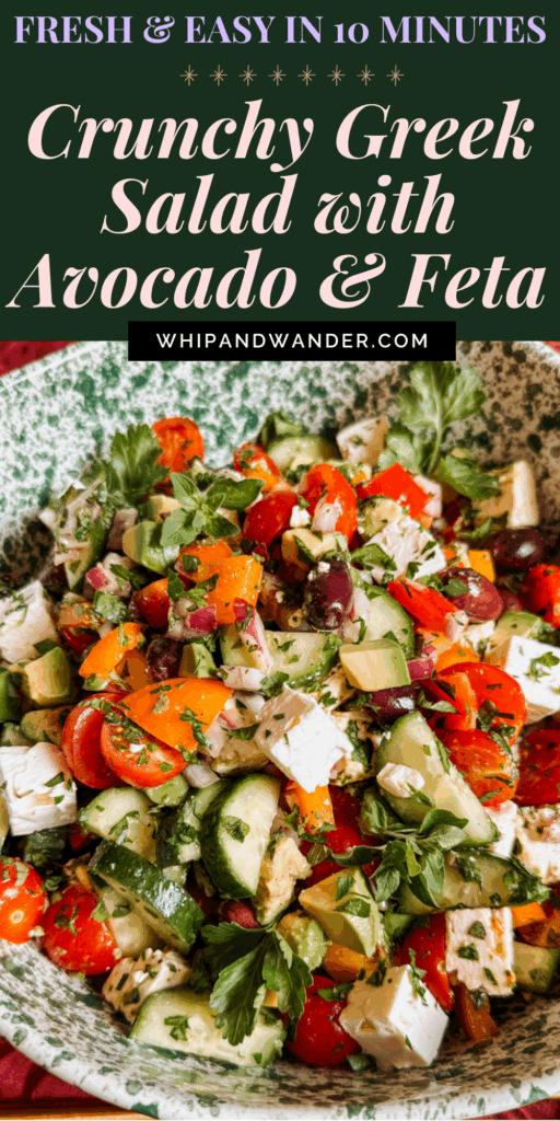 crunchy greek salad with avocado, feta, cucumbers, olives, cherry tomatoes, and herbs in a green speckled serving bowl