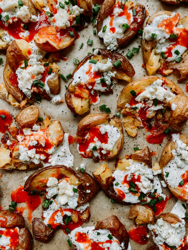 Buffalo Smashed Potatoes on a brown parchment lined baking sheet