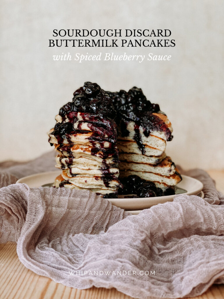a stack of sourdough buttermilk pancakes with blueberry sauce that have been cut into