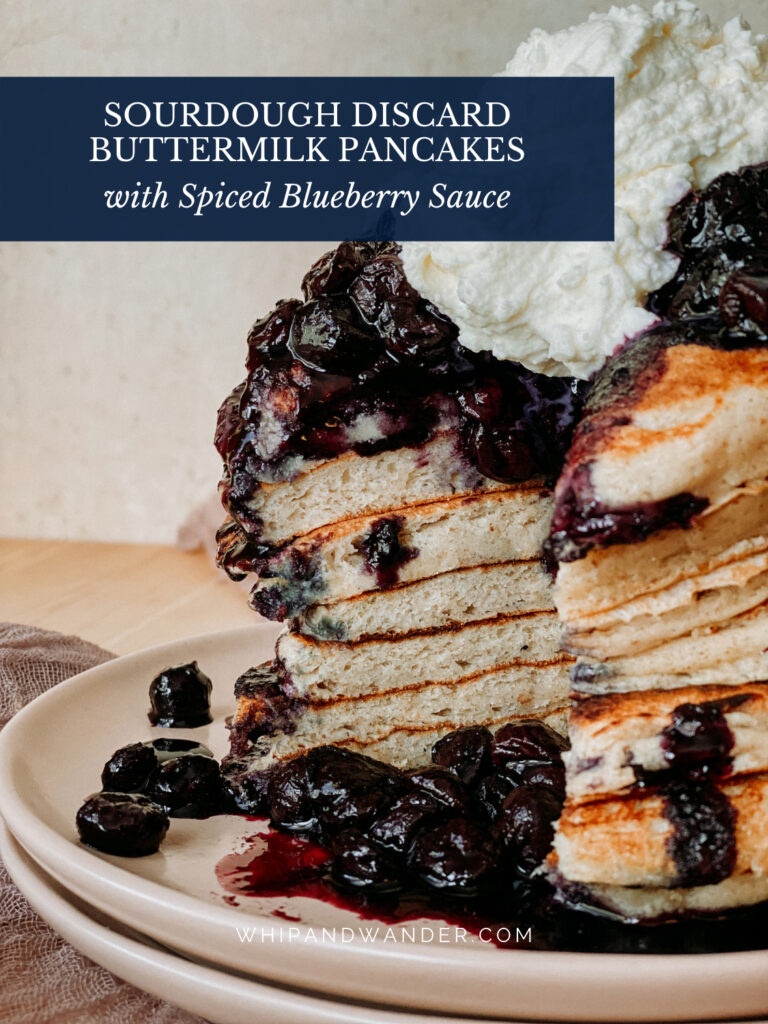 the cross section of the inside of a stack of pancakes with blueberry sauce and whipped cream