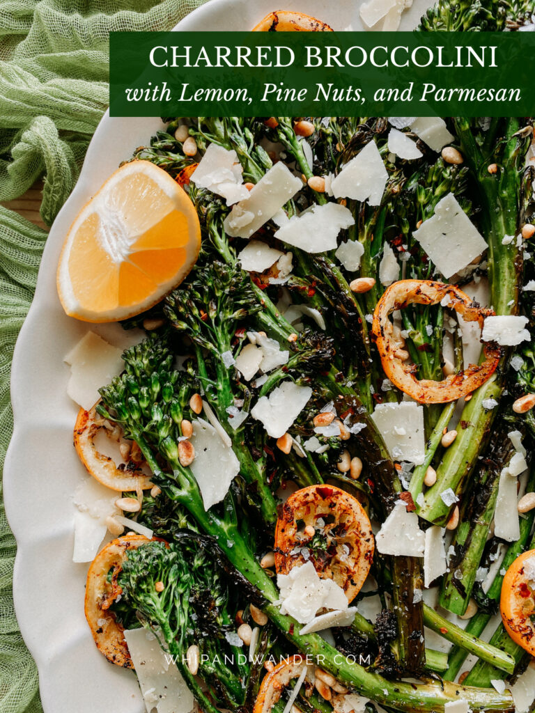 lemon slices and fresh lemon on top of charred broccolini with nuts and cheese