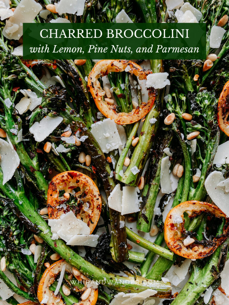 nuts and parmesan cheese on top of a platter of charred broccolini