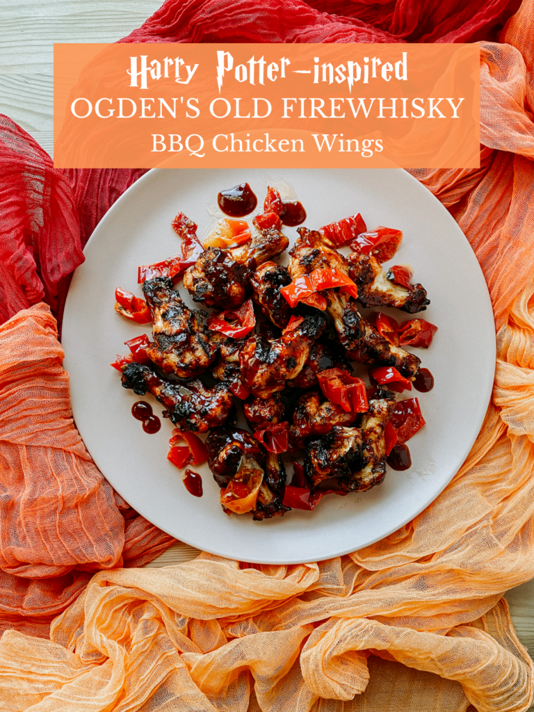 a plate of Ogden's Old Firewhisky BBQ Chicken Wings on a light pink platter on top of orange and red fabric