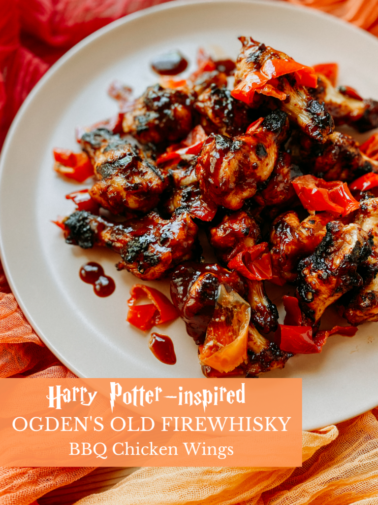 Whisky bbq chicken wings ona. light pink platter on an orange colored cloth