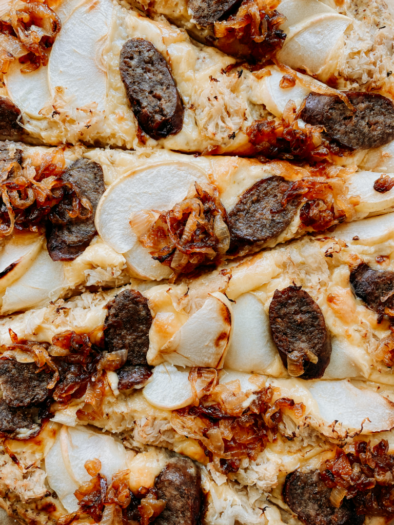 an oktoberfest pizza sliced
