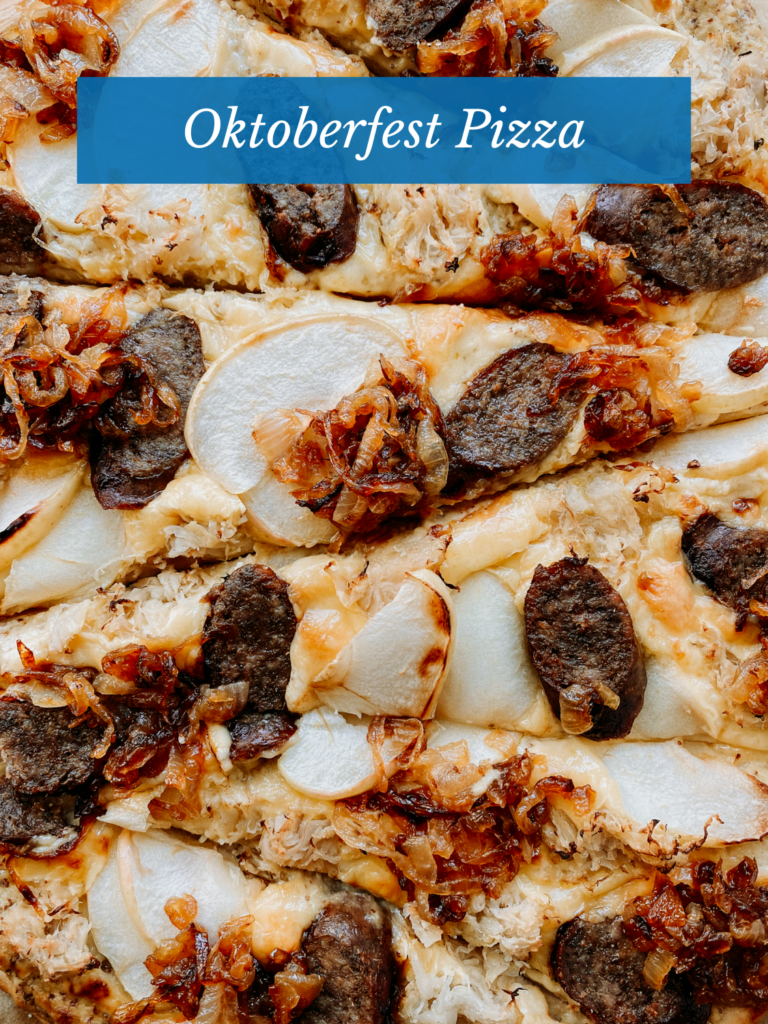 a pizza with apples and brats sliced into pieces