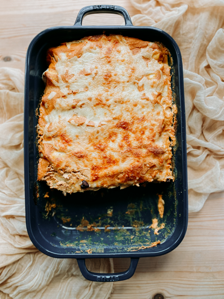 a tray of enchiladas with two missing