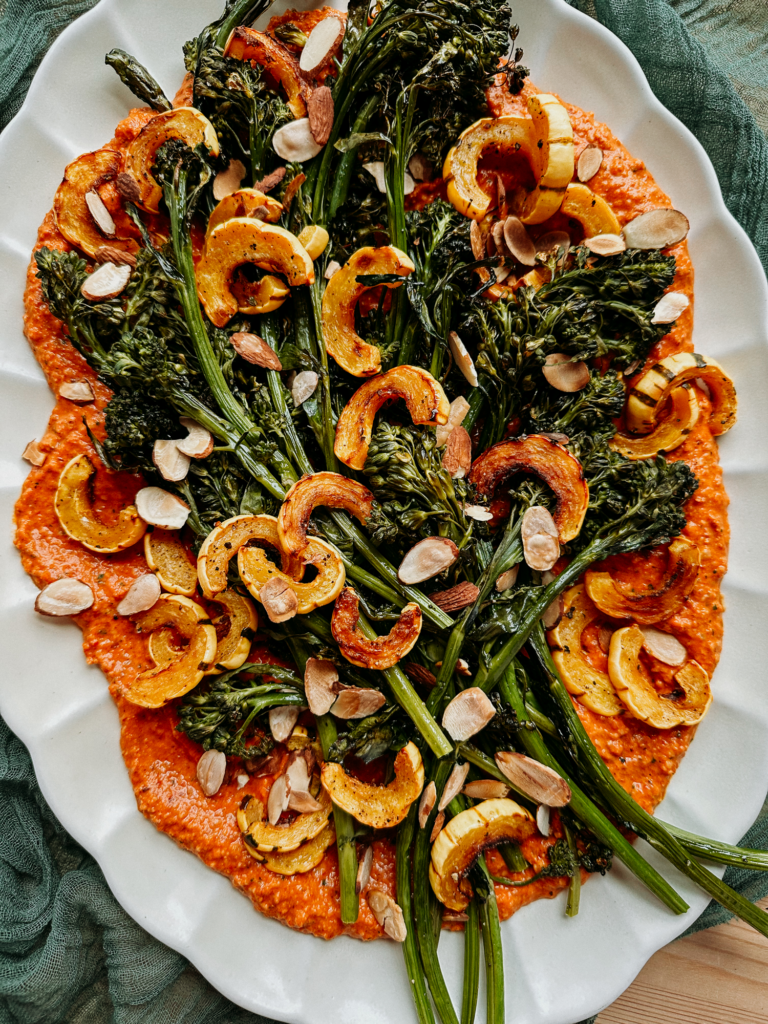 Roasted Delicata Squash and Broccolini with Romesco Sauce on a large white scalloped platter
