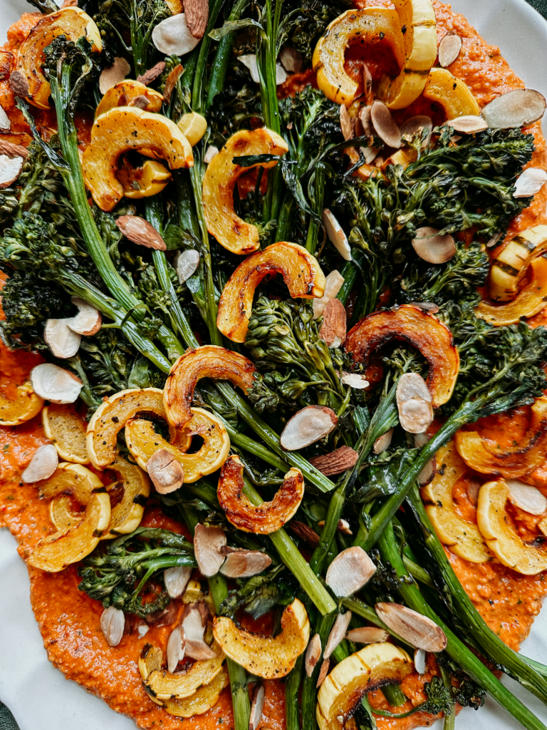 sliced toasted almonds on top of veggies and red sauce