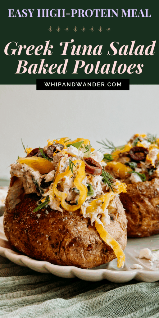Two baked potatoes stuffed with Greek tuna salad and topped with olives, feta, and pepperoncini, served on a scalloped plate.