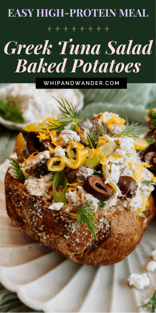A fully loaded baked potato topped with creamy tuna salad, feta, olives, and herbs, with extra toppings scattered on the plate.
