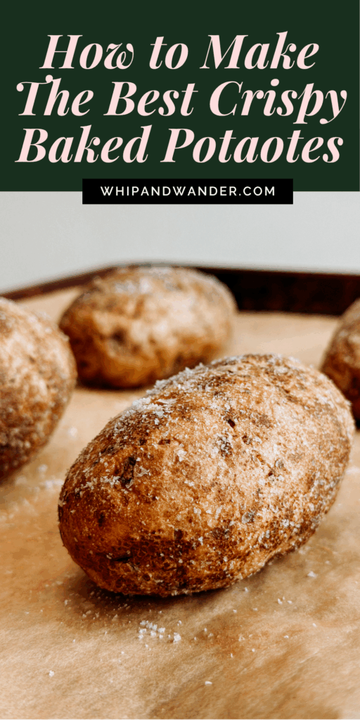 Close-up of extra crispy baked potatoes on parchment paper, one being held with a hand.