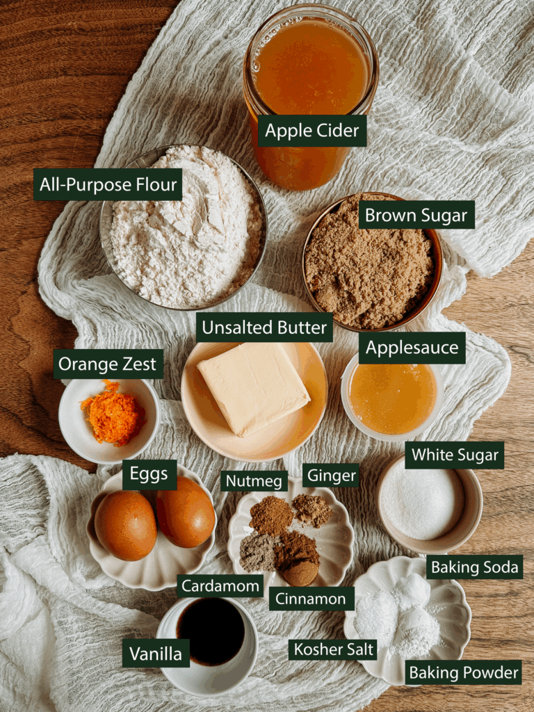 Ingredients for apple cider donut bread including cider, butter, brown sugar, flour, and spices.