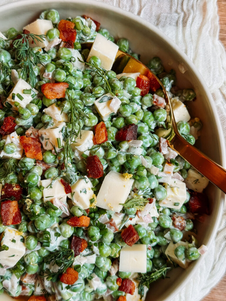 Herby pea salad with Gruyère and crispy pancetta served with a gold spoon