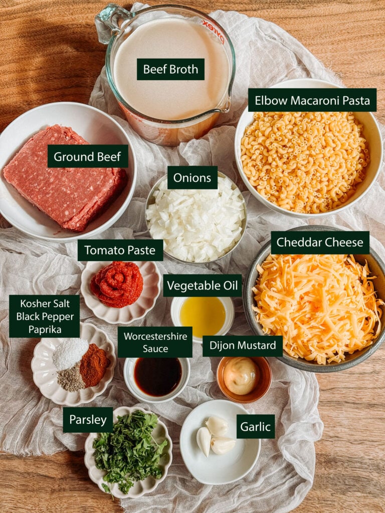 Ingredients for homemade Instant Pot Hamburger Helper, including ground beef, elbow macaroni, cheddar, onion, beef broth, tomato paste, and seasonings.